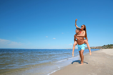 Canvas Print - Beautiful woman and her boyfriend on beach, space for text. Happy couple