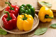 Fresh Yellow, Red And Green Bell Peppers In A Basket On Wooden Background, Organic Vegetables