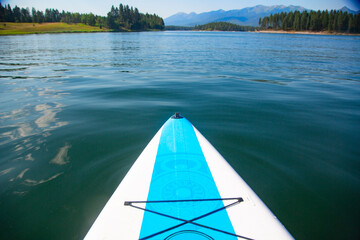 A paddle board floating on a beautiful mountain lake in Montana. Point of view photo of a scenic natural background