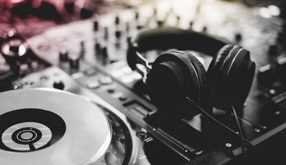 Close up of Dj mixes the track in nightclub at party. Hands of dj tweak various track controls on dj's deck.