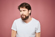© SHOTPRIME STUDIO - emotional man white t shirt sad facial expression pink background