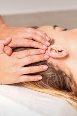 Wall Mural - Young woman receiving head massage by hands of beautician in spa beauty center