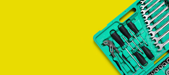 Wall Mural - Green set of construction tools: wrenches, adjustable pliers, screwdriver and so on yellow background. Banner with place for text for a hardware store. Metal hardware for professional repair or DIY