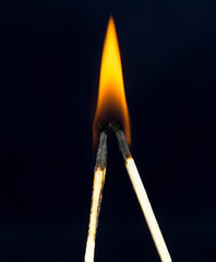 two matchstick lit on black background