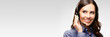 © vgstudio - Call center customer support female phone operator or sales agent in headset, copy space for some text, advertising or slogan, against grey background
