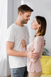© LIGHTFIELD STUDIOS - happy man and woman looking at each other while hugging at home