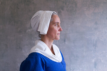 Horizontal medium side view of woman dressed in 17th Century dress and bonnet, Quebec City, Quebec, Canada