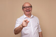 © Viktor Koldunov - Handsome senior man laughing at you, pointing finger to the camera. Studio shot