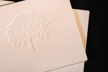 Composition of photo books in natural white leather of different sizes. The white paper on a dark background.