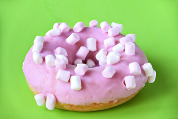 Sticker - Strawberry donut covered with pink icing on green background.