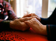 © Cavan Images - Father holding daughter's aged hands. Comforting warming old age