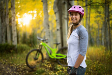 Portrait Of Smiling Female Mountain Biker In Forest