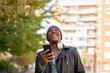 © Cavan Images - young african man in the city listening to music from his headphones