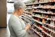 © Cavan Images - Caucasian elderly woman with white hair  shopping in supermarket