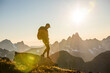 © Cavan Images - Backpacker hiking on mountain summit during sunset.