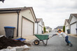 © Cavan Images - Young boy pushing wheelbarrow in lane way