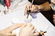© Cavan Images - Crop nail artist taking acrylic product from jar while making manicure