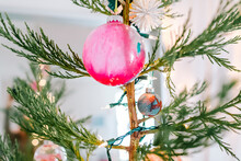 Close Up Of Pink Homemade Glass Ornament Of Natural Christmas Tree And Light