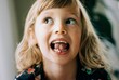 © Cavan Images - young girl with wobbly tooth pulling faces showing her tooth