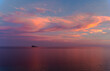 © Cavan Images - Sunset in Benidorm / Valencia / Spain with a cloudy blue and orange sky and an island at the horizon of the Mediterranean Sea with a orange, red , blue and pink color. Horizontal photo