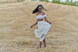 © Cavan Images - Photo session of a beautiful black woman in a wheat field with a white dress