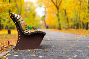 Wall Mural - Cozy bench for rest in an autumn park with yellow leaves. Autumn mood