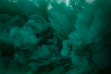 Green smoke bomb exploding against white background