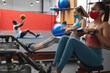 © Wavebreak Media - Two fit  caucasian woman wearing face masks performing rowing exercise in the gym