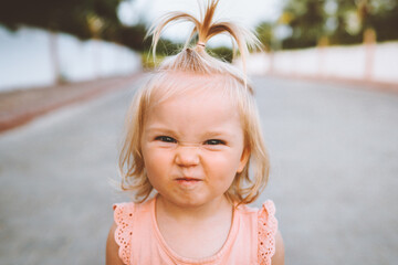 child girl smiling face portrait cute baby 1 year old candid emotions blond hair funny kid looking a