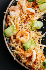 Wall Mural - Asian vegetable salad with shrimp on a black background
