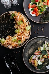 Wall Mural - Asian vegetable salad with shrimp on a black background