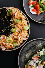 Wall Mural - Asian vegetable salad with shrimp on a black background