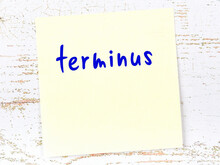 Yellow Sticky Note On Wooden Wall With Handwritten Word Terminus