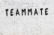Inscription teammate painted on white brick wall