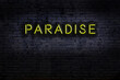 © iushakovsky - Neon sign. Word paradise against brick wall. Night view
