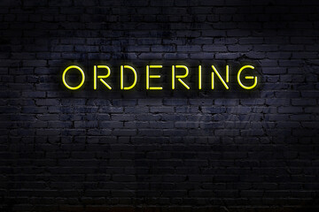 Wall Mural - Neon sign. Word ordering against brick wall. Night view