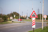 Fototapeta Miasto - Typical European railroad crossing sign on a rural road indicating an unguarded level crossing soon, with its iconic black steam locomotive on a red triangle