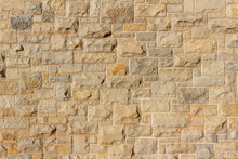 Full Frame Abstract Background Of An Attractive Tan Brown Natural Limestone Block Wall In Ashlar Pattern, With Rugged Texture Stone Blocks In Full Sunlight With Copy Space