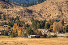 This Image Shows An Idyllic Rural Idaho Homestead Amongst A Rolling Hills Autumn Colored Landscape.