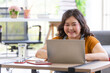 © Bangkok Click Studio - portrait of happy fat asian woman smiling and sitting on a floor typing on a computer laptop keyboard looking at camera from high angle view in a room. Working and study from home concept