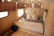 © New Africa - Stylish room interior with comfortable bed and pillows in modern trailer. Camping vacation
