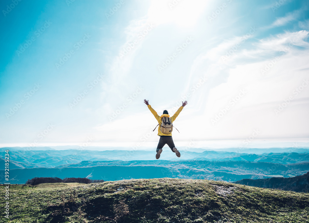 Successful man jumping on the top of the mountain - Happy hiker celebrating success - obrazy, fototapety, plakaty 