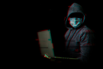 Wall Mural - Man in a mask without a face and a hood holds a laptop in his hands on a dark background. Concept of cyber rogue, hacker. Banner. Added glitch effect