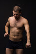 © Эльвира Кулешова - Handsome man in underwear on the black background. Muscular and athletic. Underwear man portrait. Male underwear model in studio
