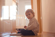© Tomsickova - Beautiful toddler blond boy, lying on the floor at home in the hall, reading book