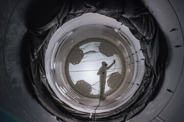 Wall Mural - worker wearing protective gear and mask spray painting tanks
