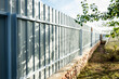 Installation of gray fence from metal profile.