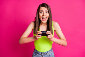 Canvas Print - Photo of positive young girl wear casual outfit play video game hold joystick isolated over pink color background