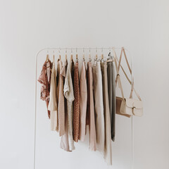 women's fashion bright pastel clothes on hanger on white background. minimalist fashion blog concept