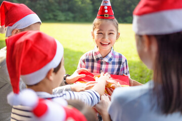 Happy children in Santa red hat and holding Christmas presents